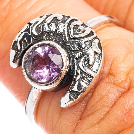 Sterling silver ring on finger with round purple amethyst gemstone and ornate setting