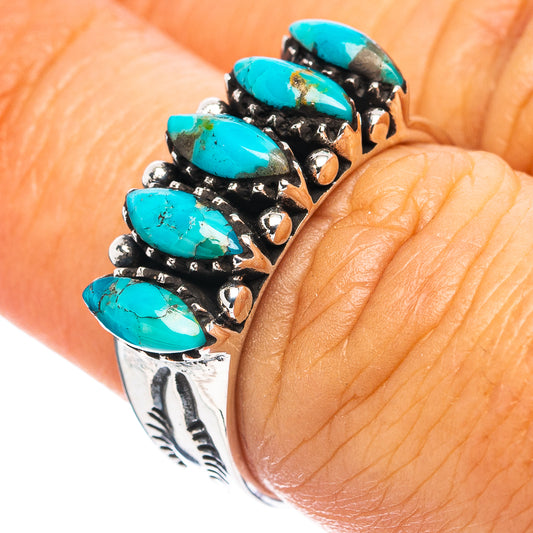 Turquoise-stone sterling silver ring on finger with black accents and engraved details