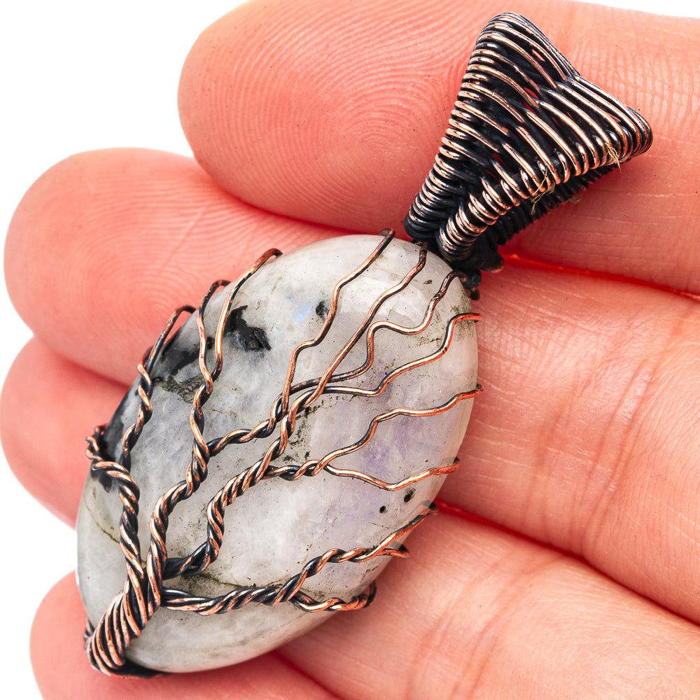 Close-up oxidized copper wire-wrapped moonstone pendant with dark stone accents