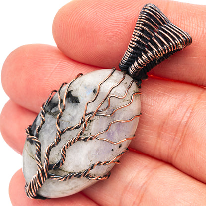 Close-up oxidized copper wire-wrapped moonstone pendant with dark stone accents