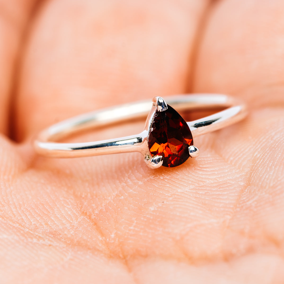 Stackable garnet ring in .925 sterling silver, pear-cut red stone in prong setting