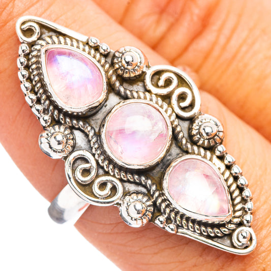 Ornate sterling silver ring featuring three pink teardrop moonstones on the hand