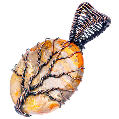 Oxidized copper wire-wrapped oval stone pendant with coiled loop bail; orange.