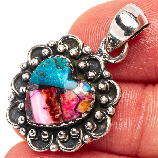 Sterling silver heart pendant with turquoise and pink stones, on fingertip