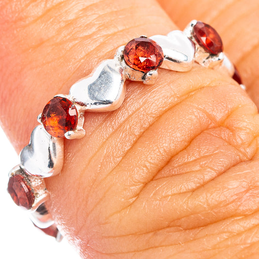 Sterling silver ring with red garnet round stones along the top, worn on finger