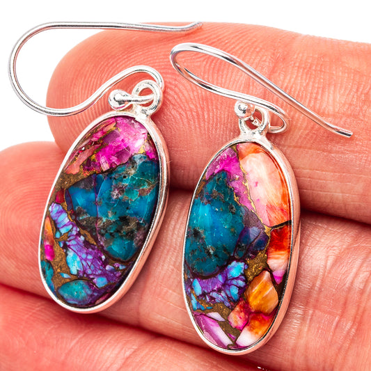 Closeup oval turquoise dangle earrings with pink, blue, and gold stone in .925 silver