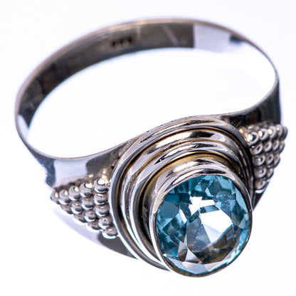 Sterling silver ring with blue round gemstone in swirl bezel, side view, size 9
