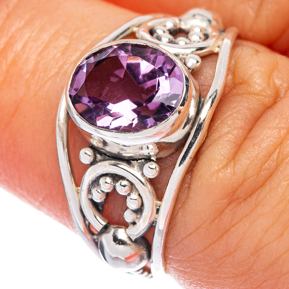 Sterling silver amethyst ring close-up with faceted round-oval gem and side scrollwork
