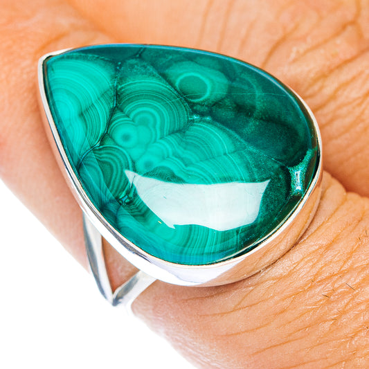 Teardrop malachite ring with polished sterling-silver bezel, shown on a finger.