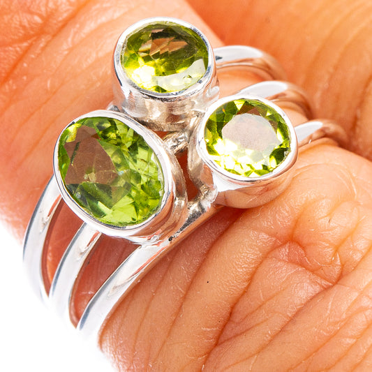 Sterling silver ring with three round green peridot gemstones on an open setting