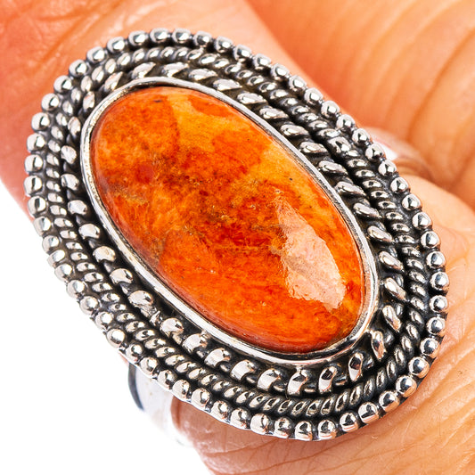 Oval orange coral gemstone ring in .925 sterling silver bezel with textured border