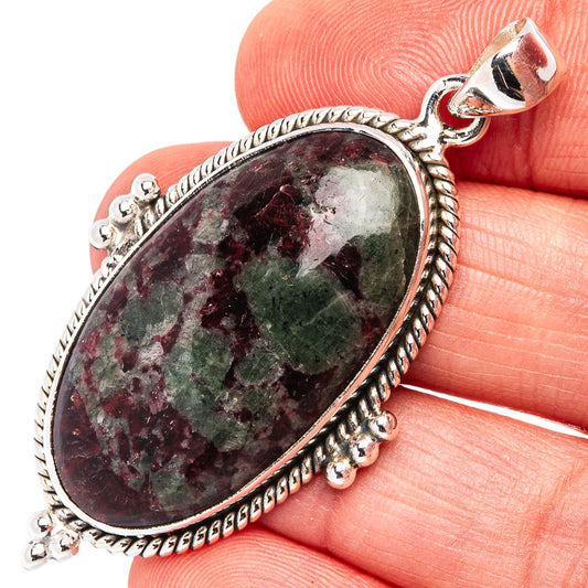 Oval eudialyte pendant in ornate .925 sterling silver with top loop and dangling side charms