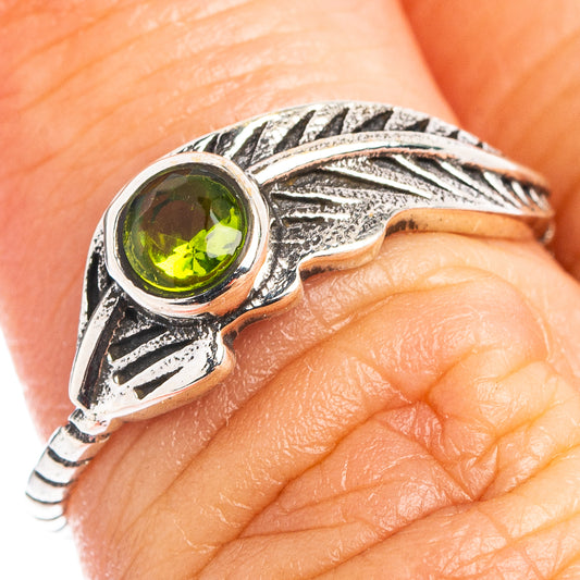 Sterling silver feather ring with round green peridot gemstone, textured leaf-like band