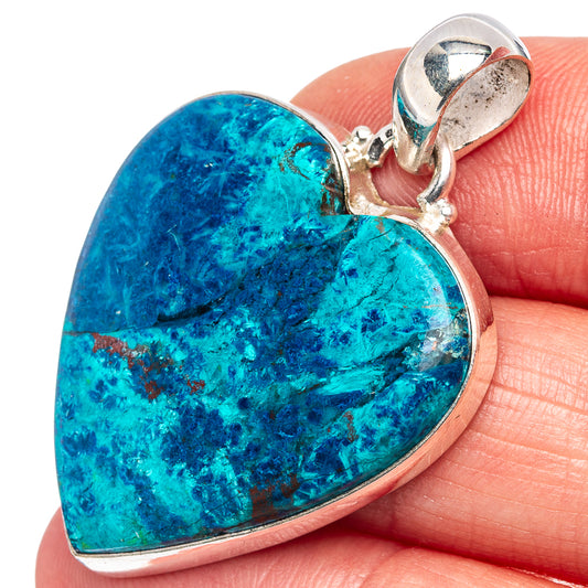Blue heart shattuckite pendant with sterling silver bail, resting on fingertip