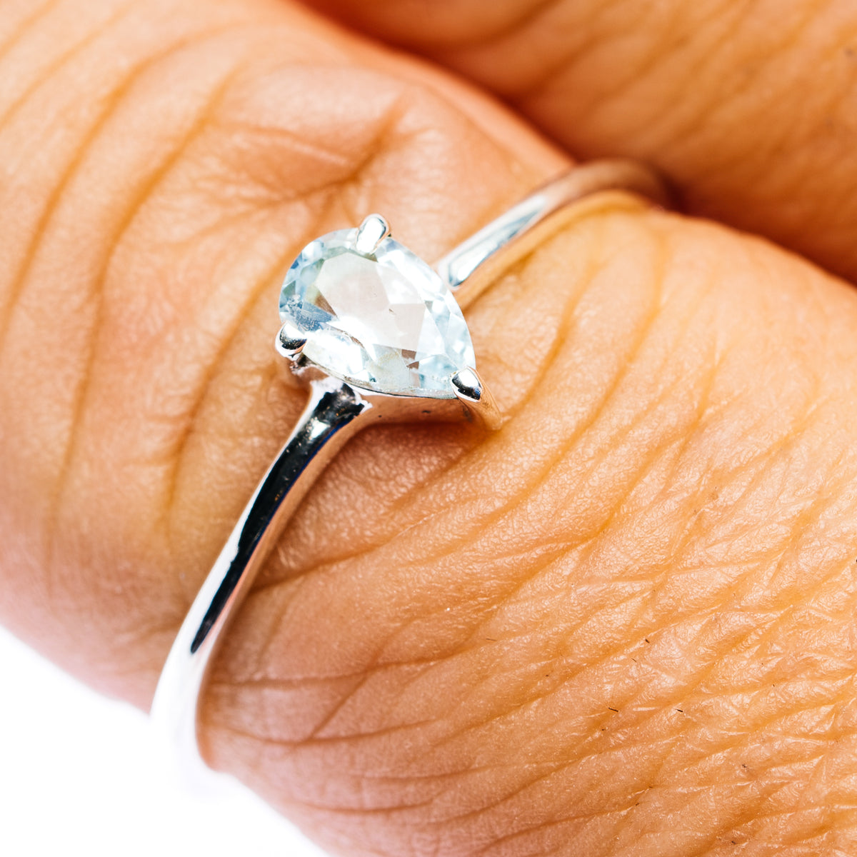 Blue topaz stackable ring in .925 sterling silver, oval light-blue gemstone on finger