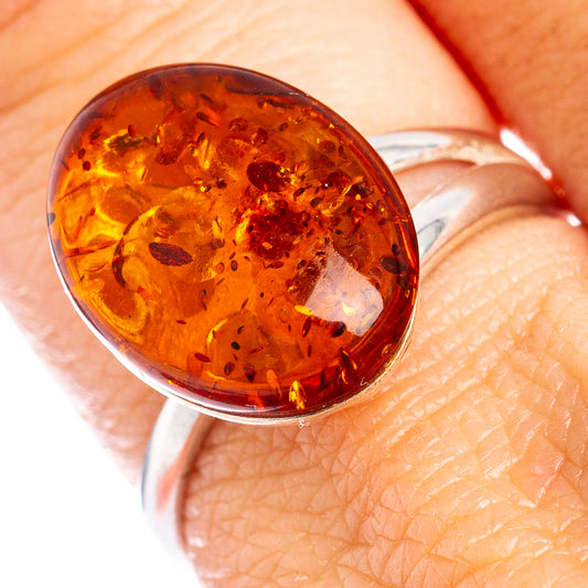 Amber oval cabochon ring in 925 sterling silver, close-up on finger
