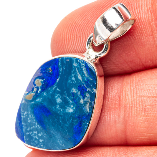 Sterling silver opal pendant with teardrop blue gemstone on bail, held in hand