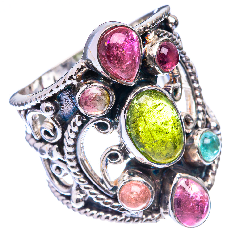 Ornate silver ring with green oval stone, pink cabochons, and small round accents