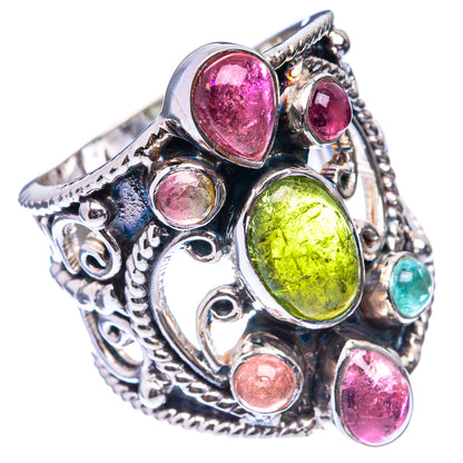 Ornate silver ring with green oval stone, pink cabochons, and small round accents