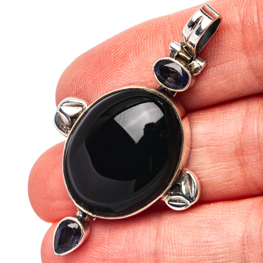 Sterling silver oval black onyx pendant with three dark blue iolite accents