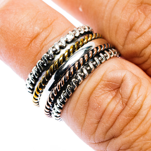 Spinner ring with braided silver and gold-tone bands on finger