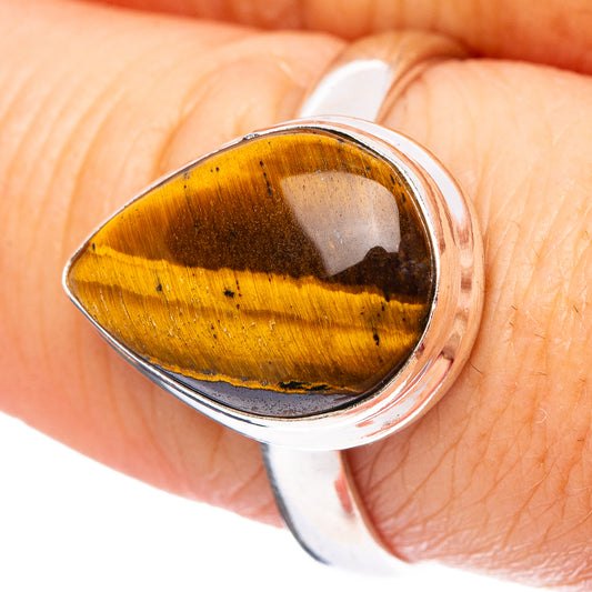 Sterling silver tiger’s eye ring with faceted oval cabochon stone on finger