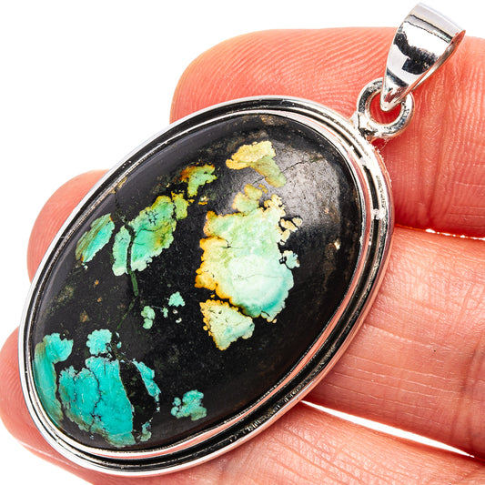 Turquoise cabochon pendant with oval black matrix and sterling silver frame, bail visible