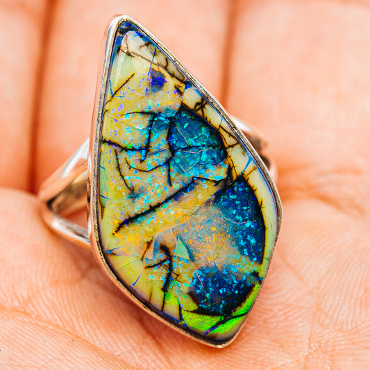 Oval opal ring in sterling silver, vivid blue center with yellow-green background, side view.
