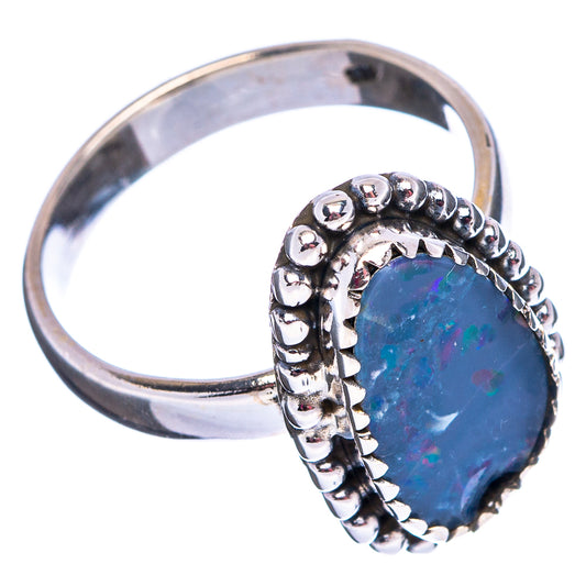 Sterling silver ring featuring a large oval blue opal with ornate beaded prongs.
