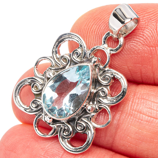 Sterling silver pendant with oval blue topaz gemstone in ornate bezel setting