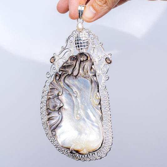 Mother-of-pearl teardrop pendant with ornate .925 sterling silver filigree and pearl bail