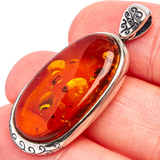 Oval Baltic amber pendant in .925 sterling silver bezel with ornate bail