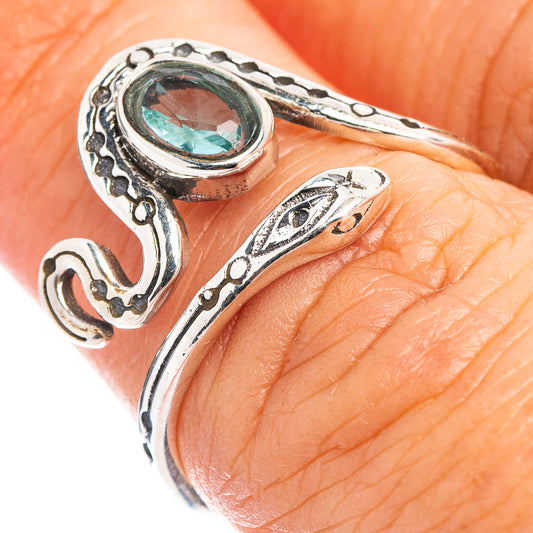 Sterling silver snake ring with oval blue gemstone bezel, close-up on finger