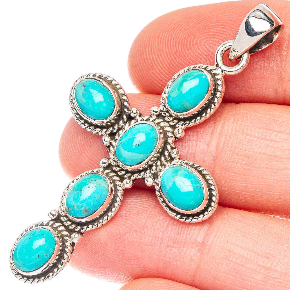 Silver cross pendant with five turquoise cabochons and ornate bezel settings