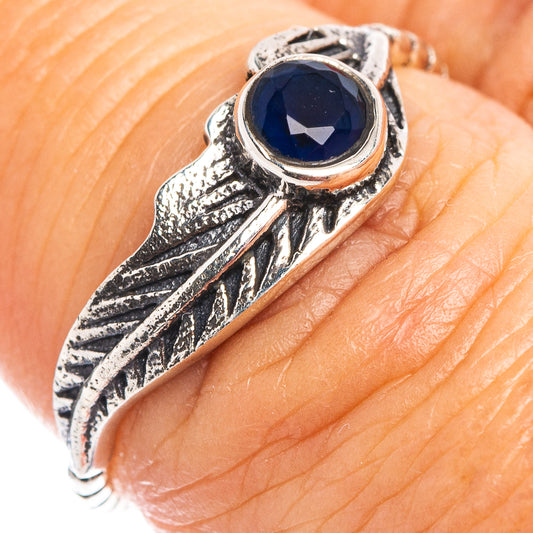 Sterling silver feather-style ring with blue round gemstone set on band