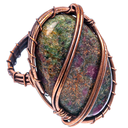Oxidized copper wire-wrapped ring with oval multicolor stone, top view.