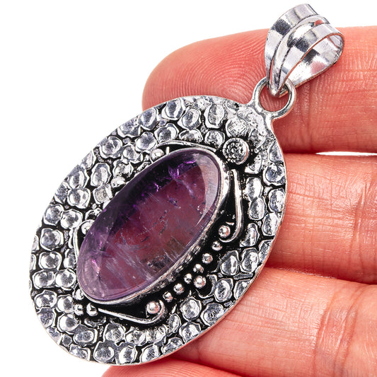Antique silver oval amethyst pendant with ornate textured border and bail