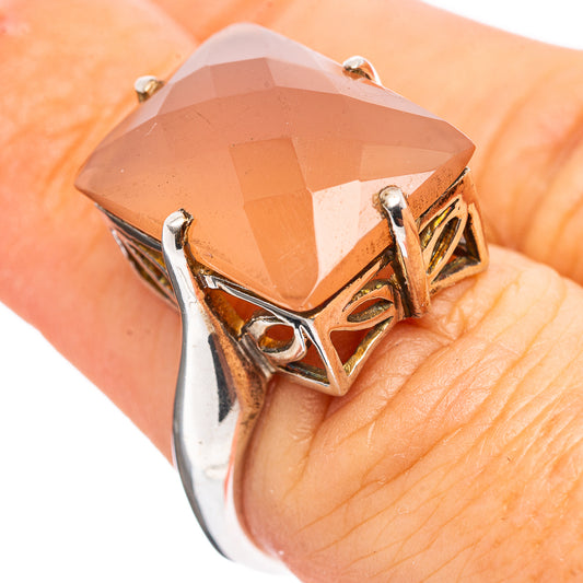 Peach faceted gemstone ring on hand, silver openwork bezel with claw prongs