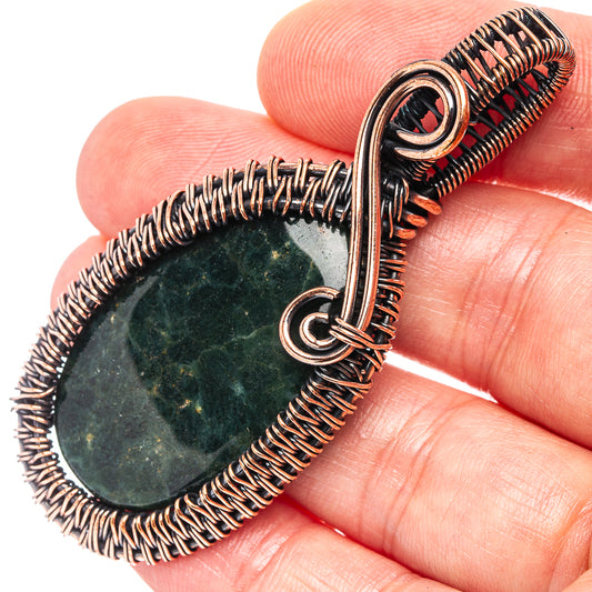 Ocean jasper wire wrap pendant detail: oxidized copper frame with small metal loop
