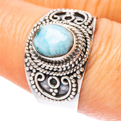 Sterling silver ring with oval light-blue larimar cabochon and ornate engraved band