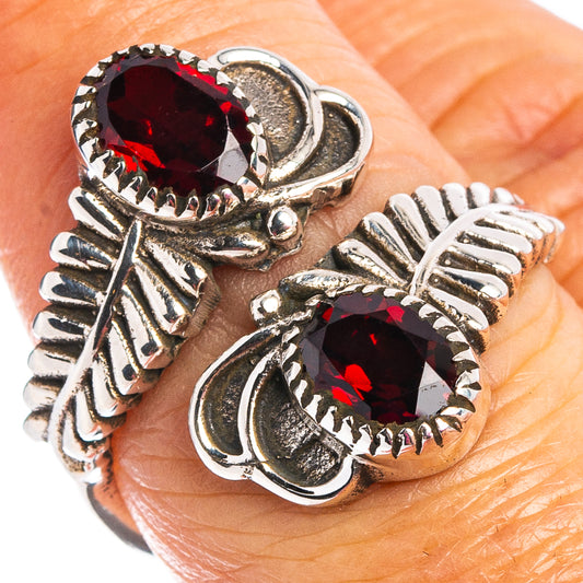 Faceted garnet ring with two dark red stones, ornate silver setting, side details