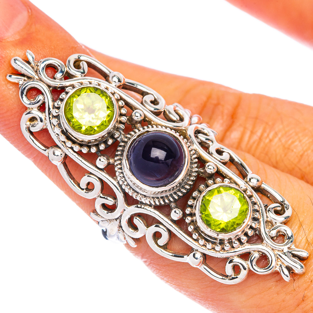 Sterling silver ring with oval green peridot and dark blue tanzanite stones, ornate filigree