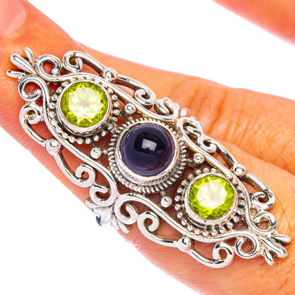 Sterling silver ring with oval green peridot and dark blue tanzanite stones, ornate filigree