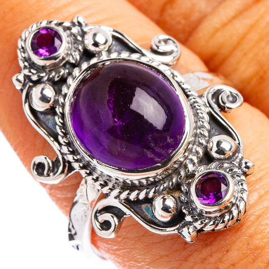 Amethyst cabochon sterling silver ring with oval center stone and small purple accents