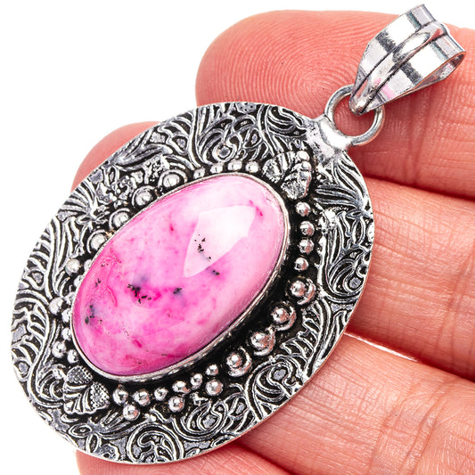 Pink dendritic opal pendant in ornate silver-tone oval frame with top loop bail