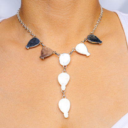 Silver necklace with dark blue teardrop charms and white oval drop pendants