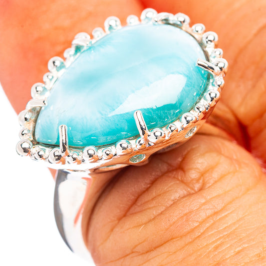 Sterling silver larimar ring with oval light-blue cabochon and beaded halo.