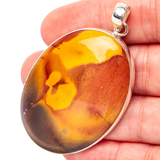 Mookaite oval cabochon pendant with silver bail, shown on hand