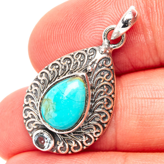 Sterling silver pendant with turquoise pear center, ornate filigree frame, two round gems