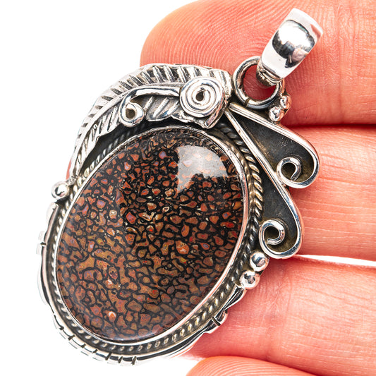 Sterling silver oval dinosaur bone inlay pendant with ornate bezel and bail